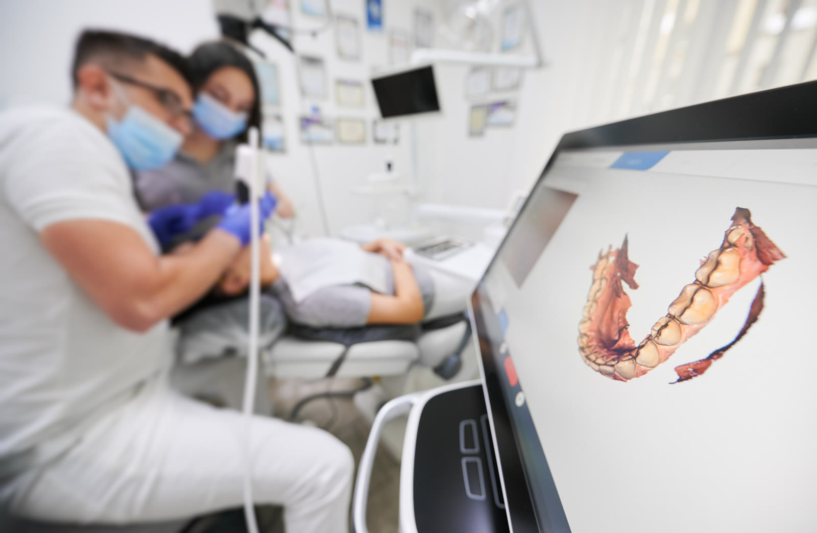 Dentist scanning a patient’s teeth with an intraoral scanner